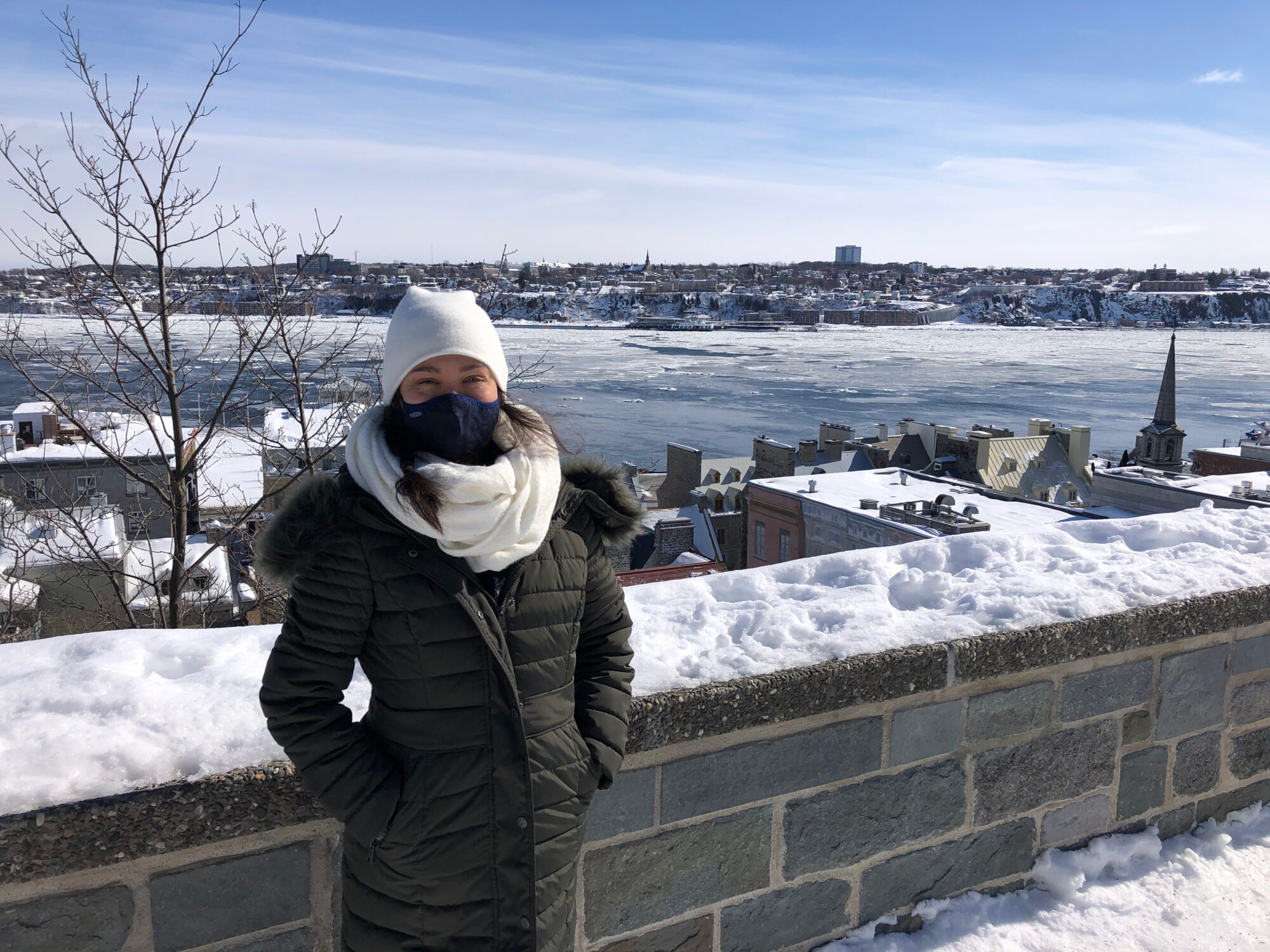 Girl in front of stone wall with frozen river in background