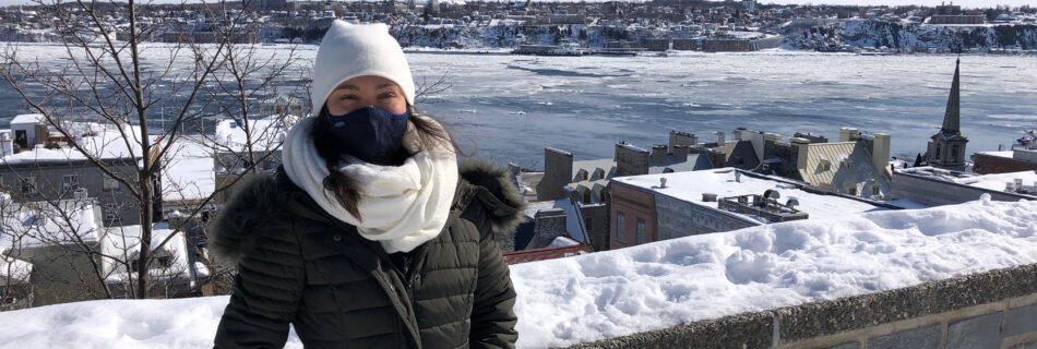 Girl in front of stone wall with frozen river in background