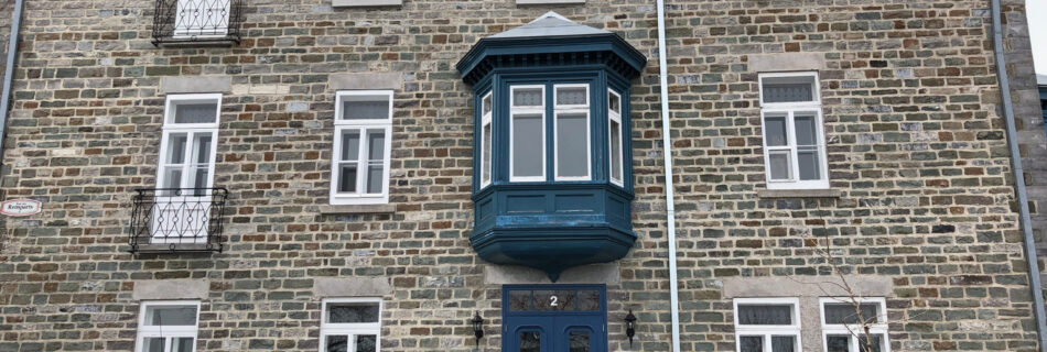 Mini Cooper car in front of stone building